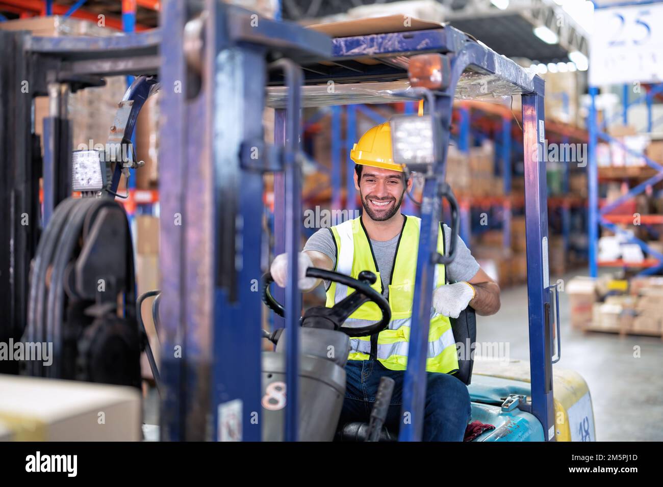 Forklift Truck Operator Lifts Pallet Cardboard Boxes On a Shelf by ...