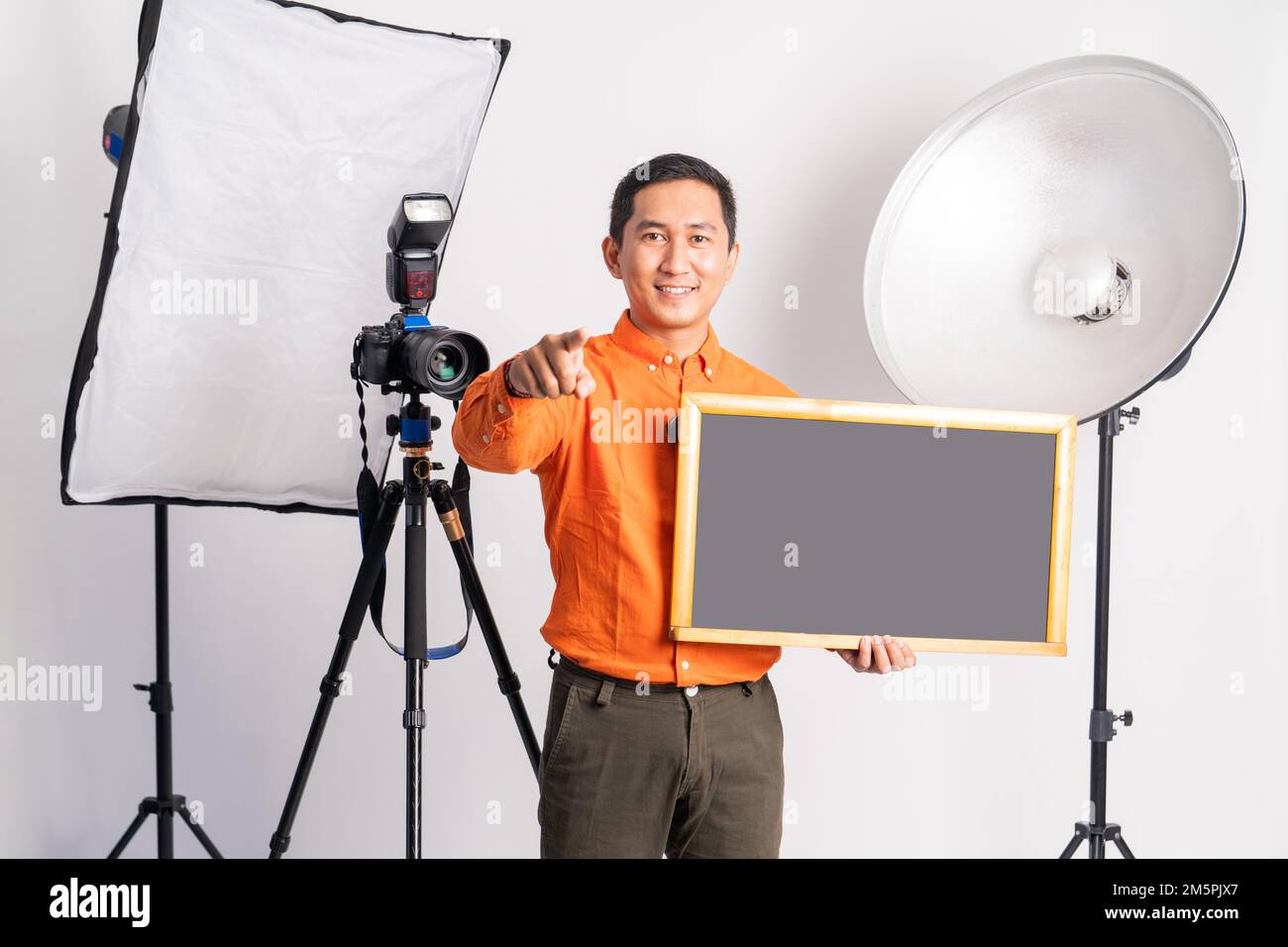 vlogger standing with hand pointing at camera while holding blackboard Stock Photo