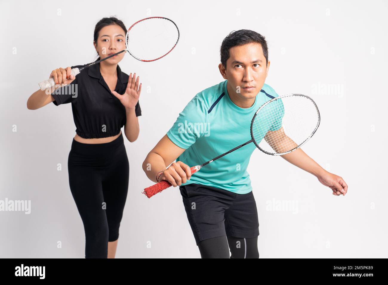 asian man and woman standing ready to hold racket Stock Photo