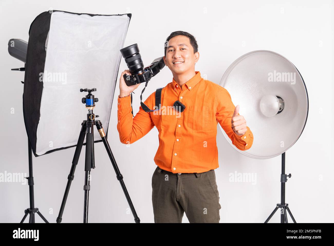 smiling man holding dslr camera with thumbs up Stock Photo - Alamy