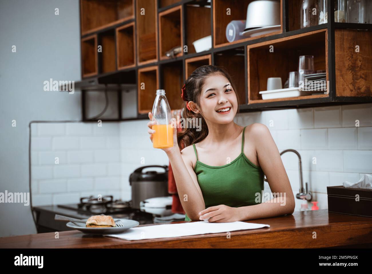 attractive asian girl smiling while holding orange bottle Stock Photo