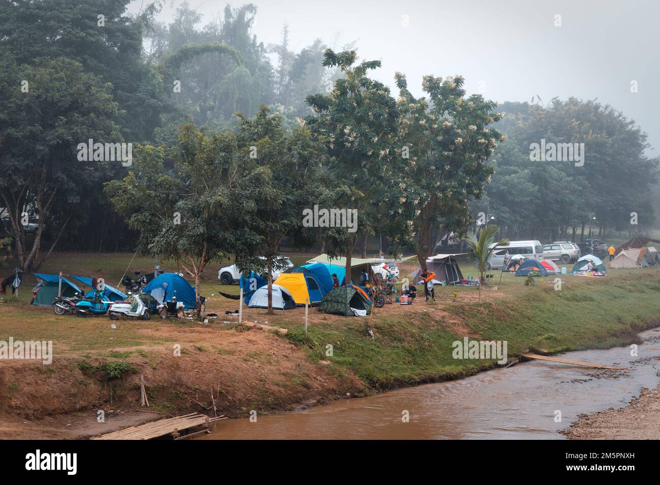 Pai, Thailand. November 19, 2022. Camping site with tents next to river Pai Stock Photo