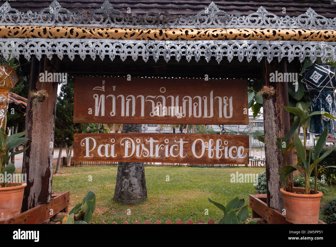 Sign saying Pai District Office in Thai and in English outside the government office in Pai, Thailand Stock Photo