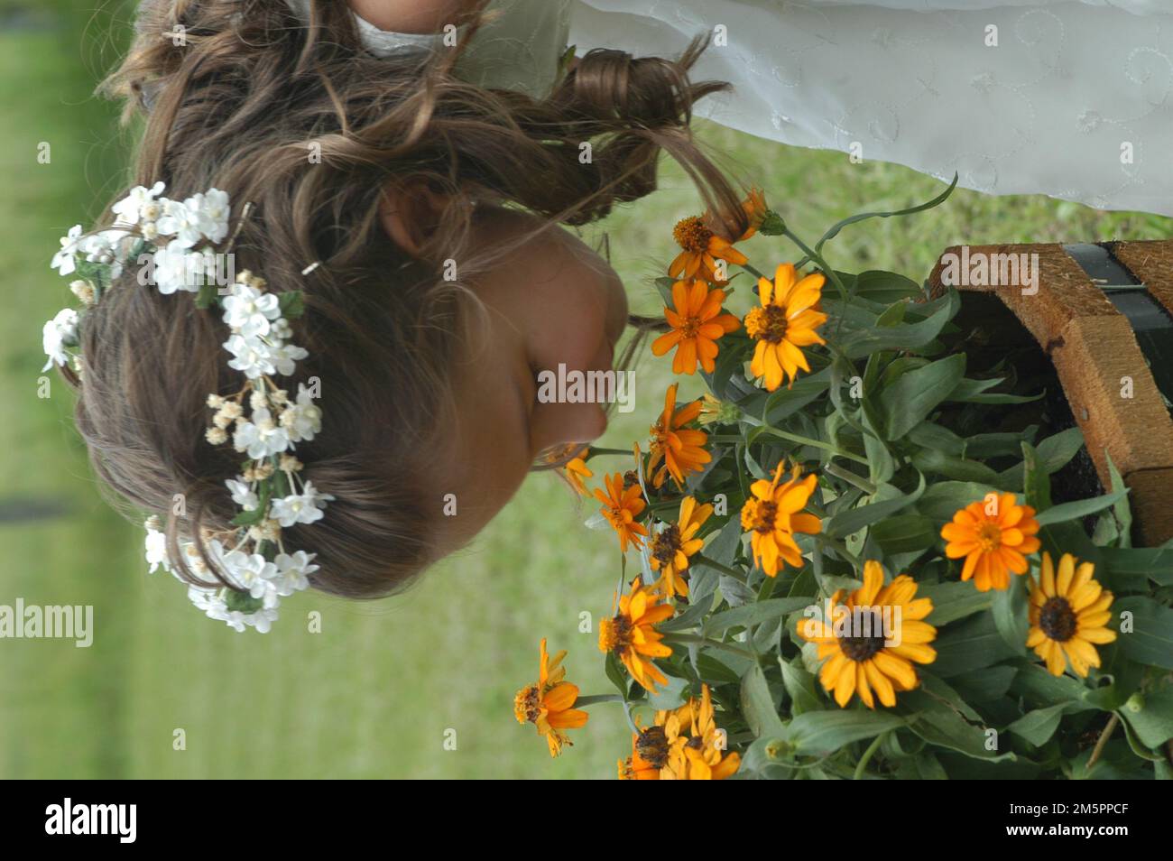 Flower girl outside summer wedding yellow flowers Stock Photo
