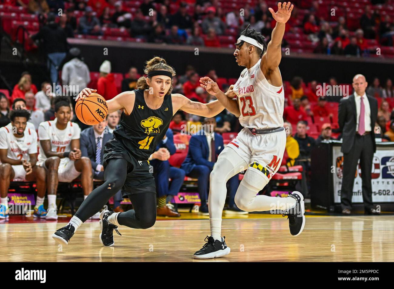 College Park, MD, USA. 29th Dec, 2022. UMBC Retrievers guard Jacob Boonyasith (41) dribbles against the defense of Maryland Terrapins guard Ian Martinez (23) during the NCAA basketball game between the UMBC Retrievers and the Maryland Terrapins at Xfinity Center in College Park, MD. Reggie Hildred/CSM/Alamy Live News Stock Photo