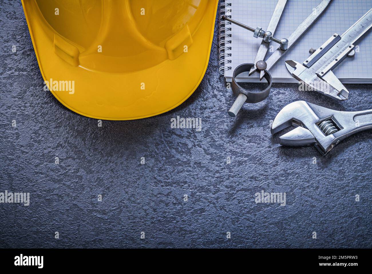 Notebook building helmet compasses vernier scale adjustable spanner construction concept. Stock Photo