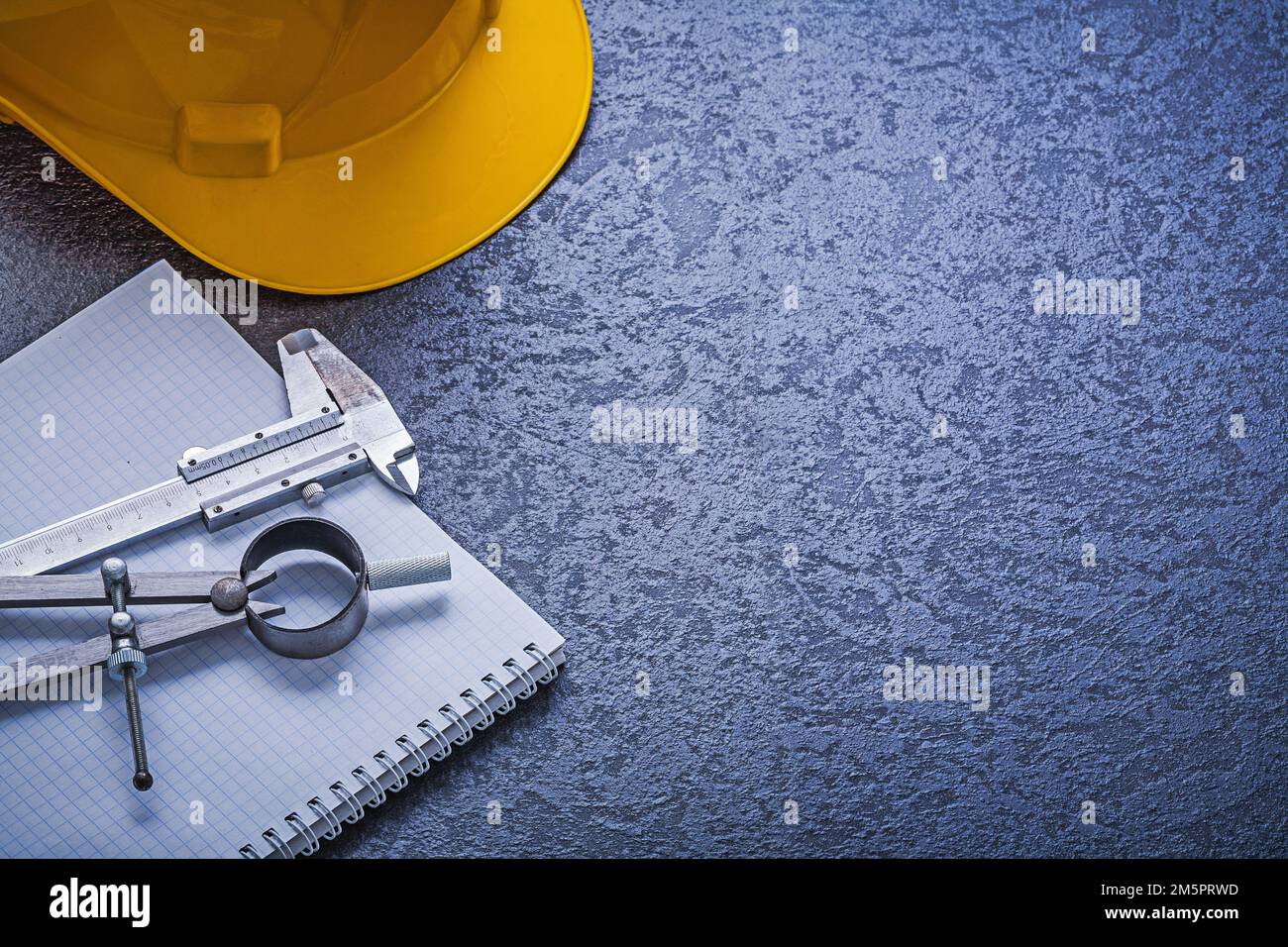 Notebook building helmet compasses vernier scale construction concept. Stock Photo