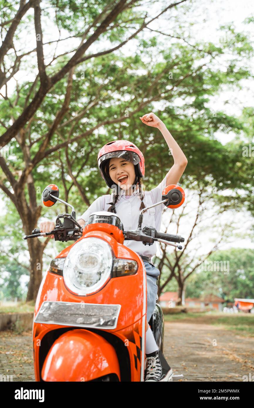 student girl is excited to celebrate by riding a motorcycle Stock Photo
