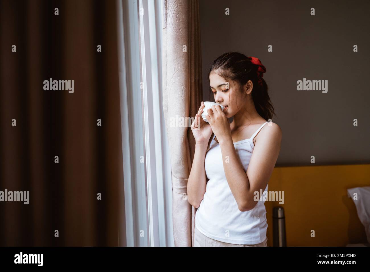 girl drinking coffee in front of the window Stock Photo