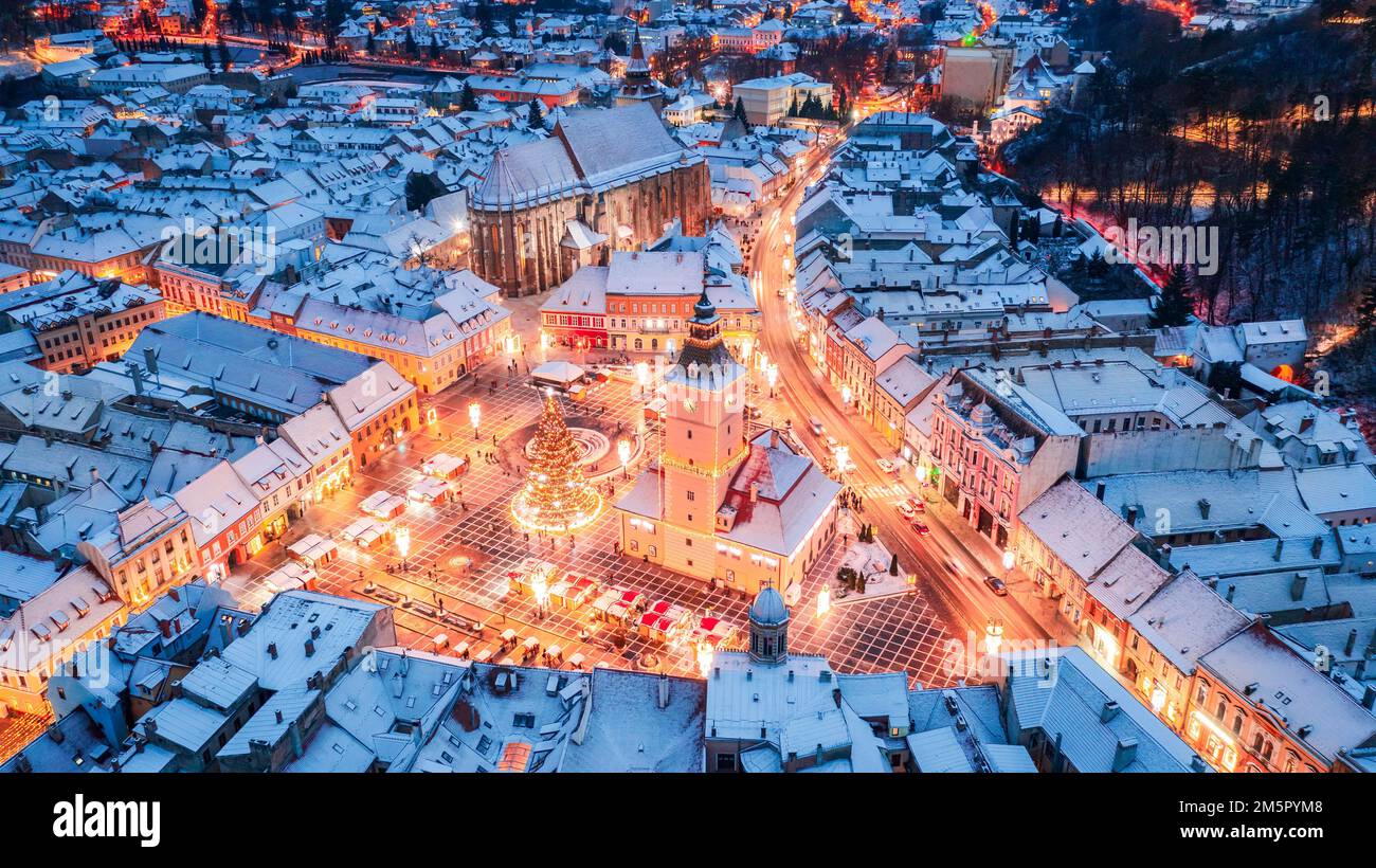 Brasov, Romania. Xmas 2022 aerial drone view with snowy Christmas Market and Council Square, Transylvania landmark. Stock Photo