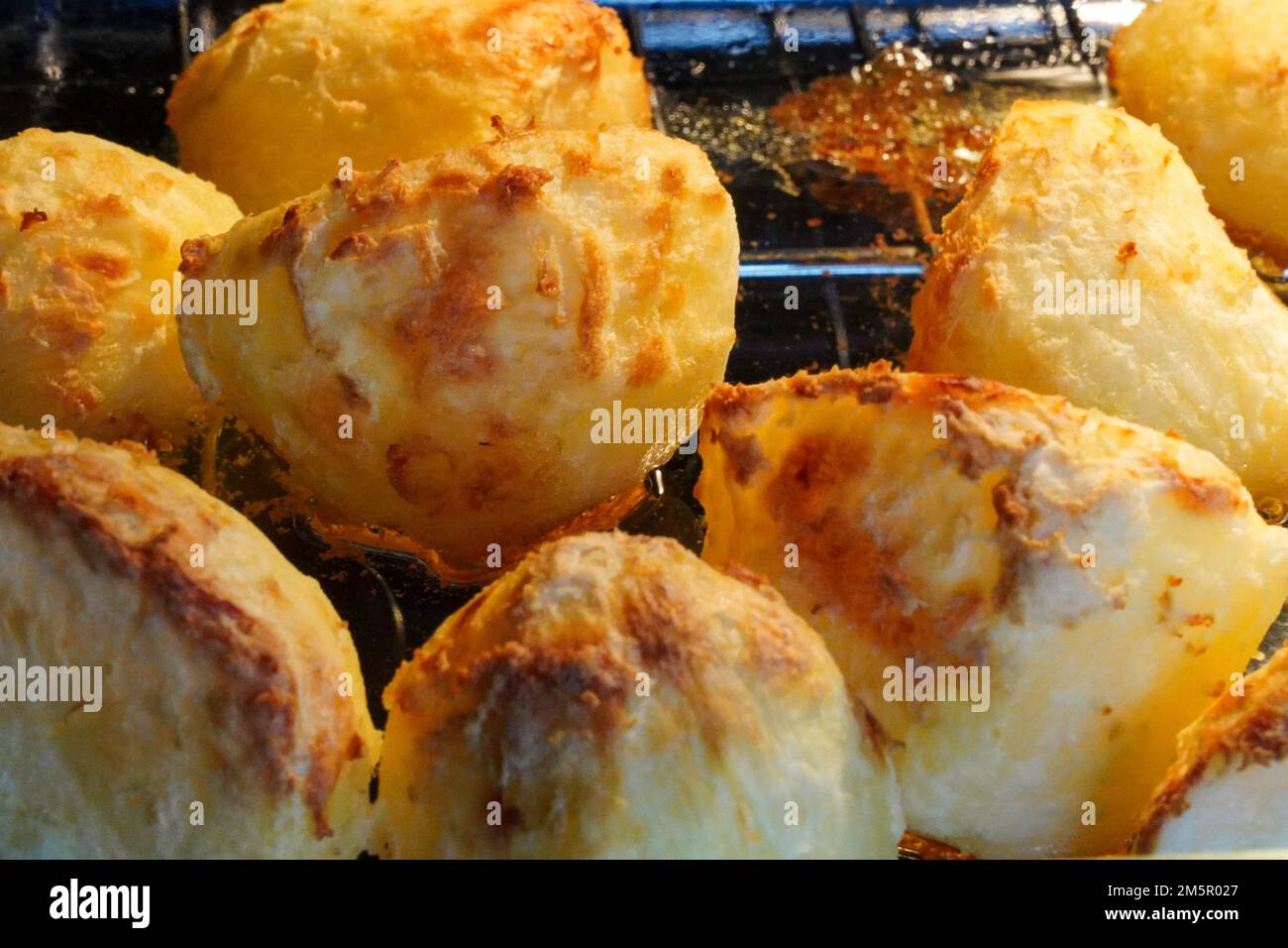 Golden potatoes cooking, roasting in the oven in goose fat Stock Photo