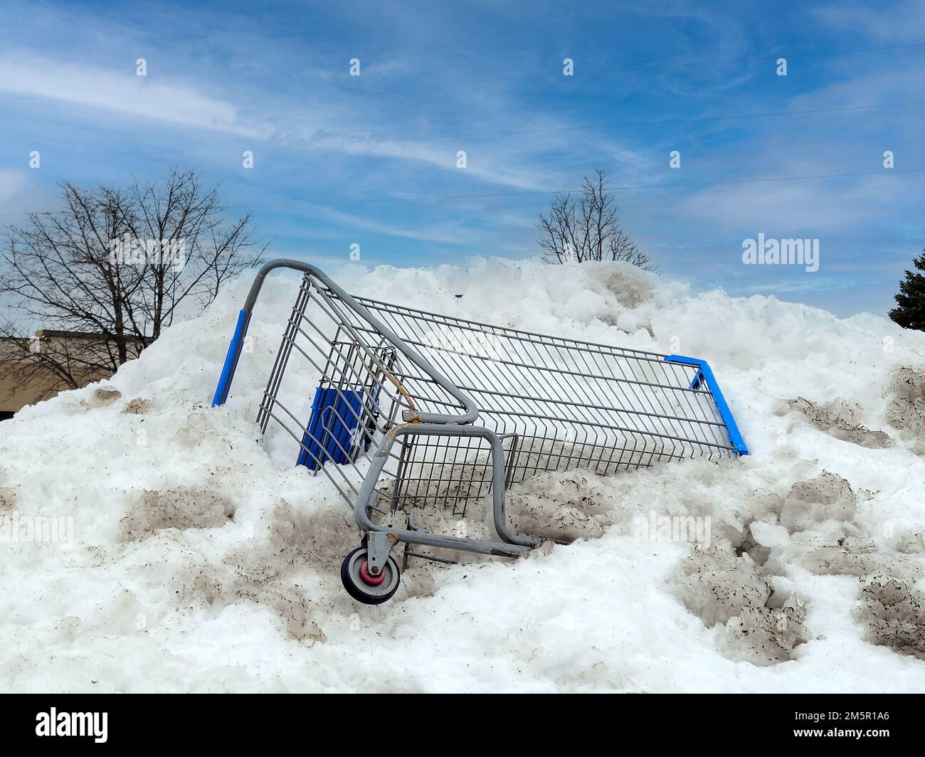Shopping cart stuck in a dirty snow bank Stock Photo Alamy