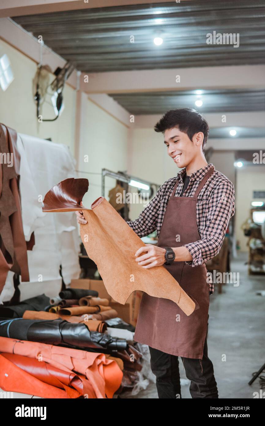 Craftsman take tanned leather from leather craft materials Stock Photo