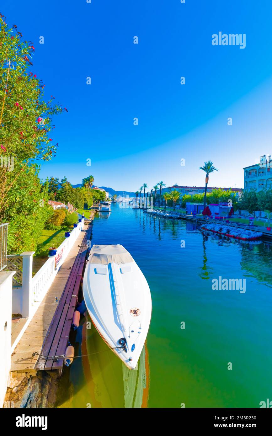 A vertical shot of a boat on the surface of a river under the blue sky ...