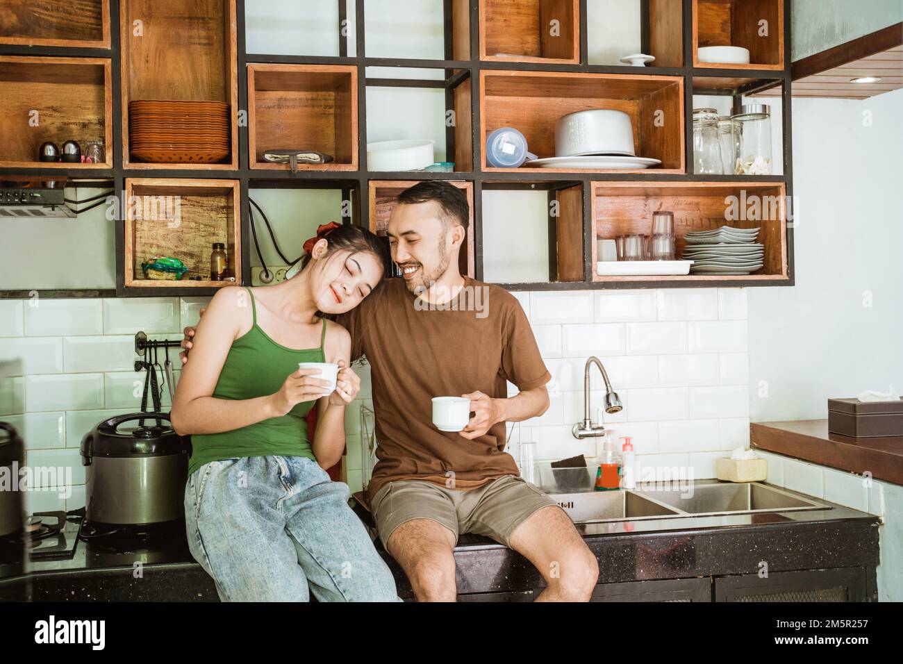 asian man and woman dating while drinking coffee using cup Stock Photo