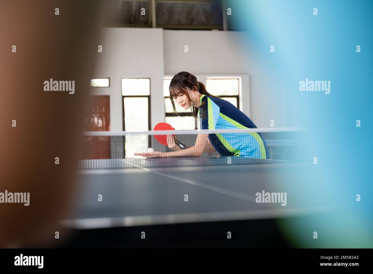 Female athlete holding paddle and ball while serving Stock Photo