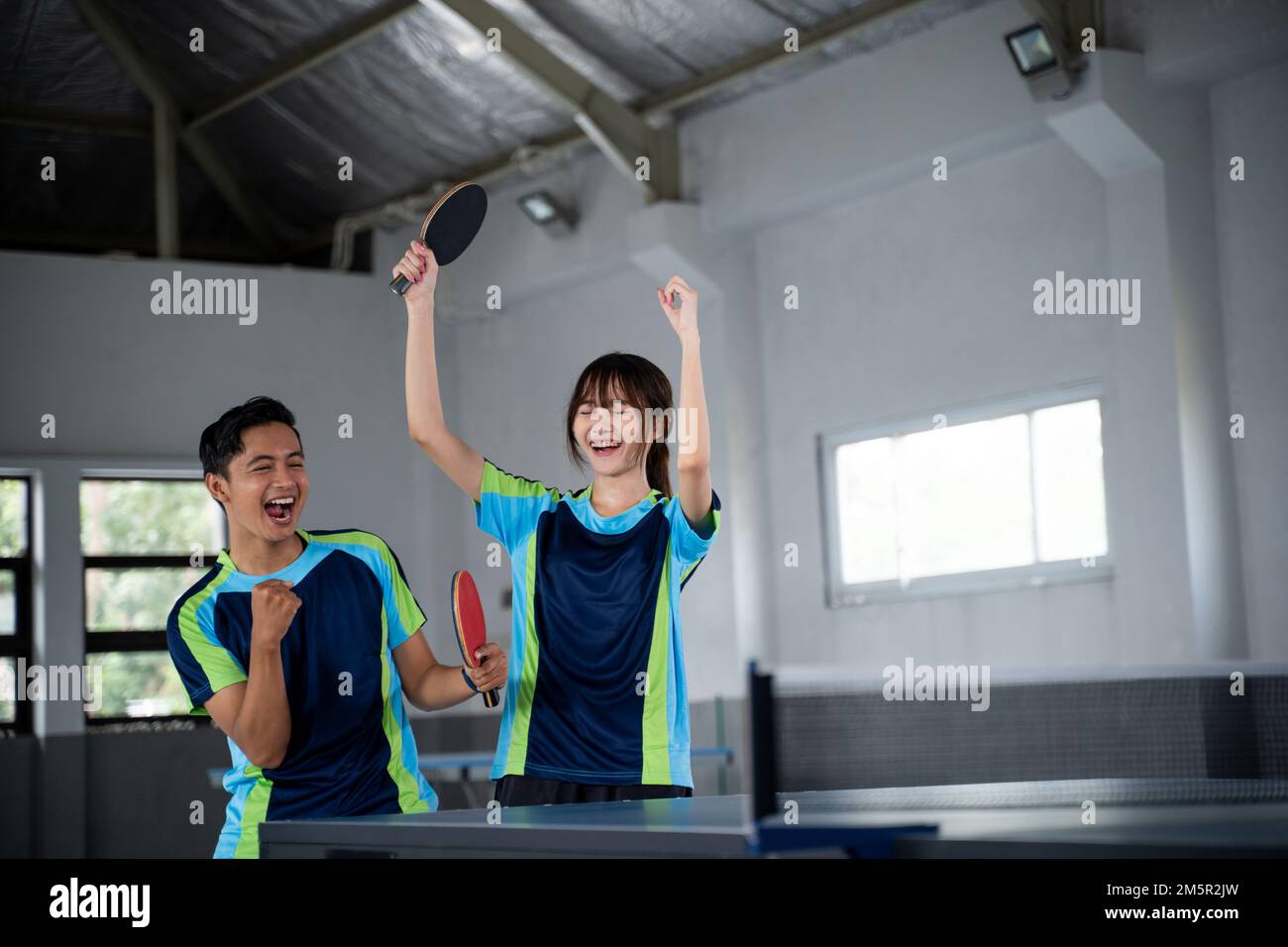 male and female asian ping pong players happy to score Stock Photo