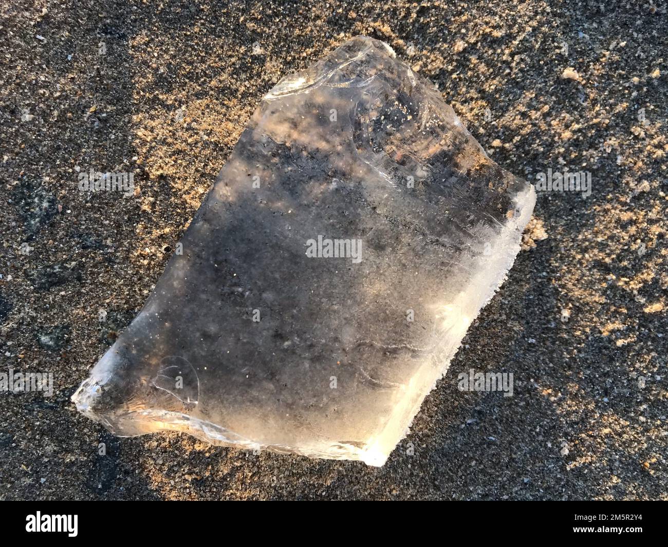 Ice on a beach concept image reflecting issues like climate change, extreme weather events or ideas like contrasts (hot versus cold, summer v winter). Stock Photo