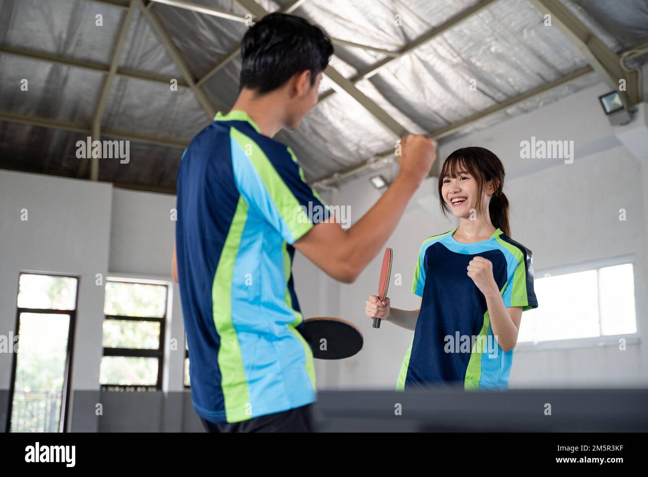 Two asian ping pong players excited while competing Stock Photo