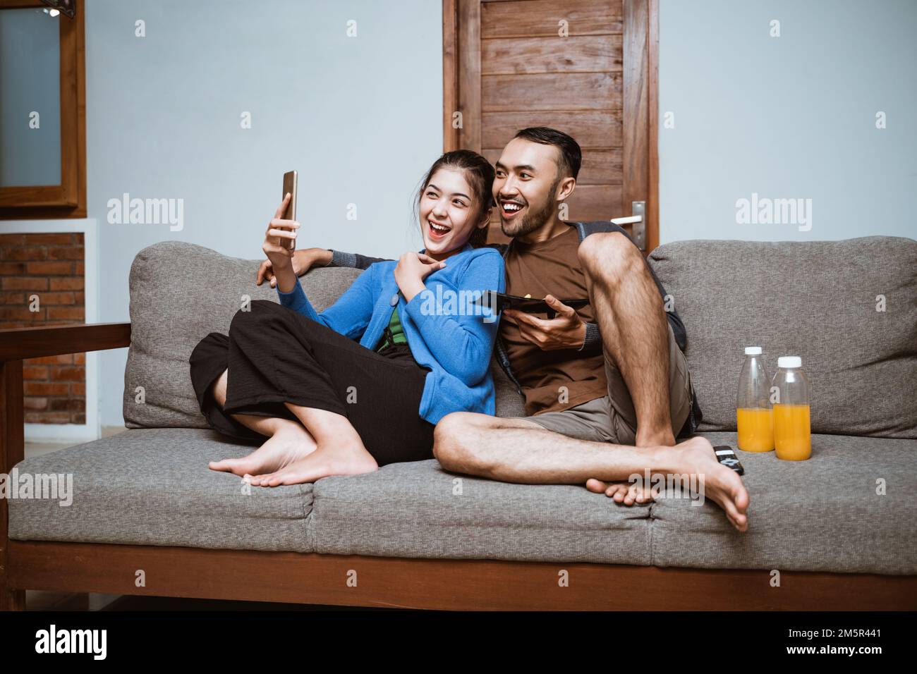 young asian woman and man making video call using smartphone Stock Photo
