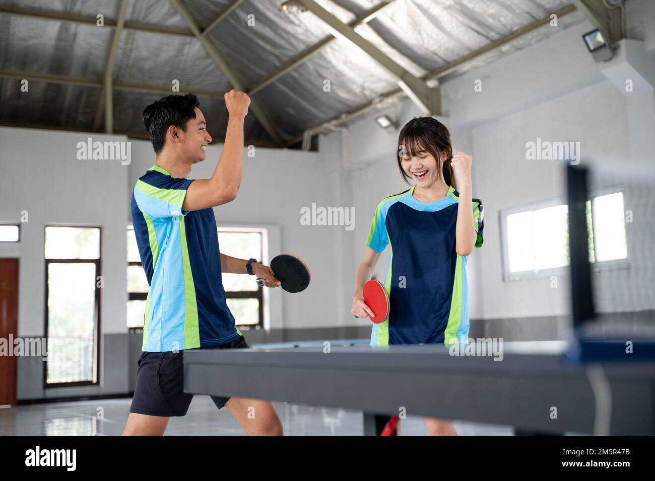 Two ping pong players encourage each other while competing Stock Photo