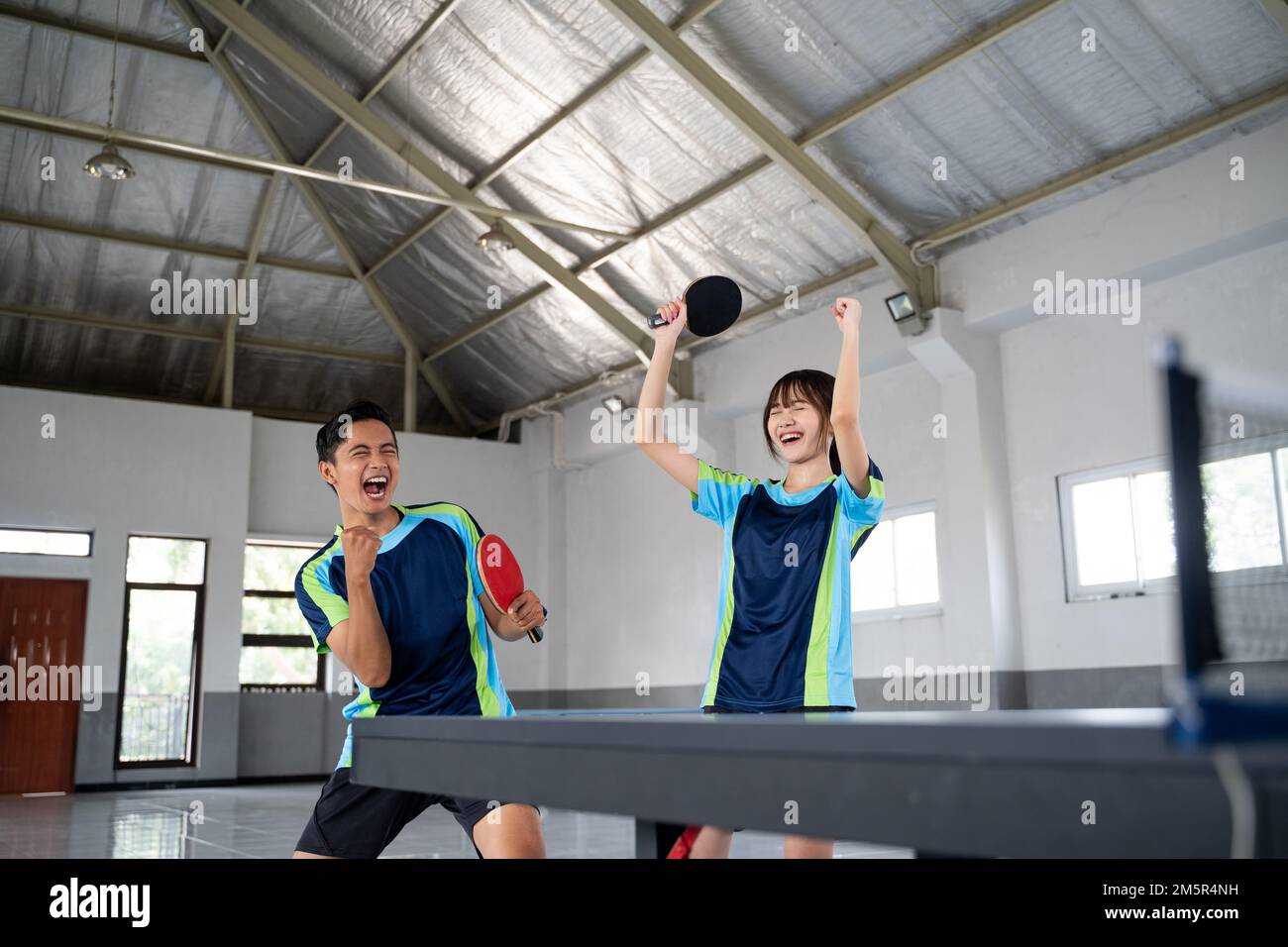 male and female ping pong players happy to score Stock Photo
