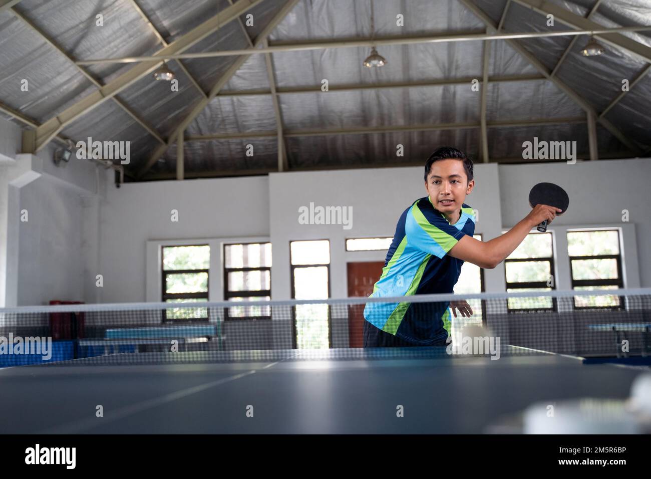 Asian male athlete hitting in a ping pong match Stock Photo