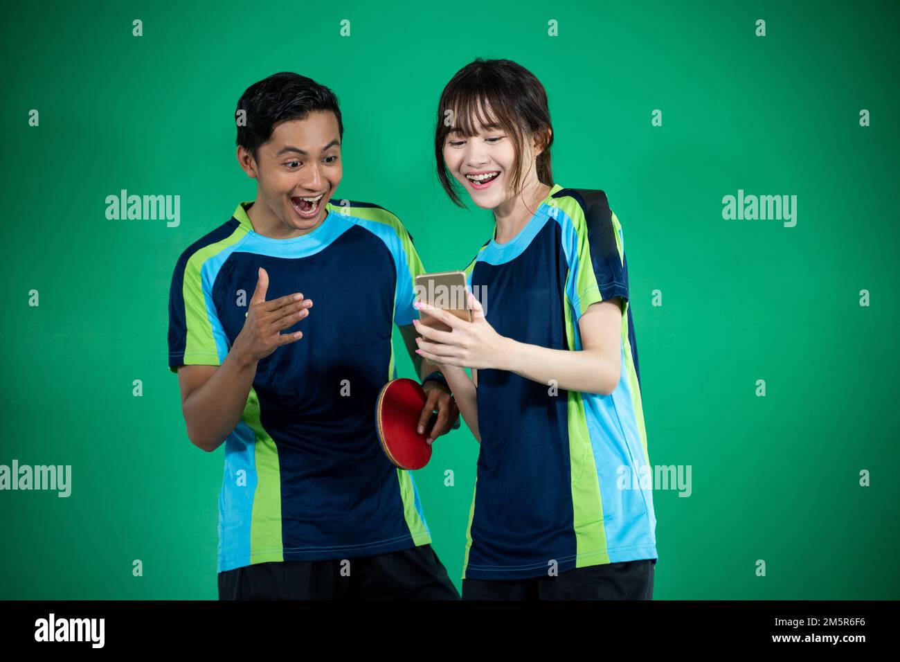 Asian female and male athletes excited to look at smartphones Stock Photo