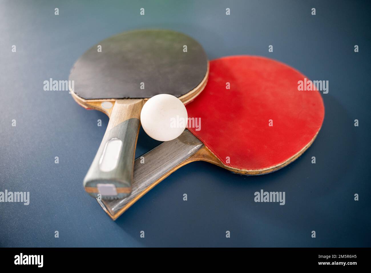 ping pong ball with two paddles on a blue table Stock Photo