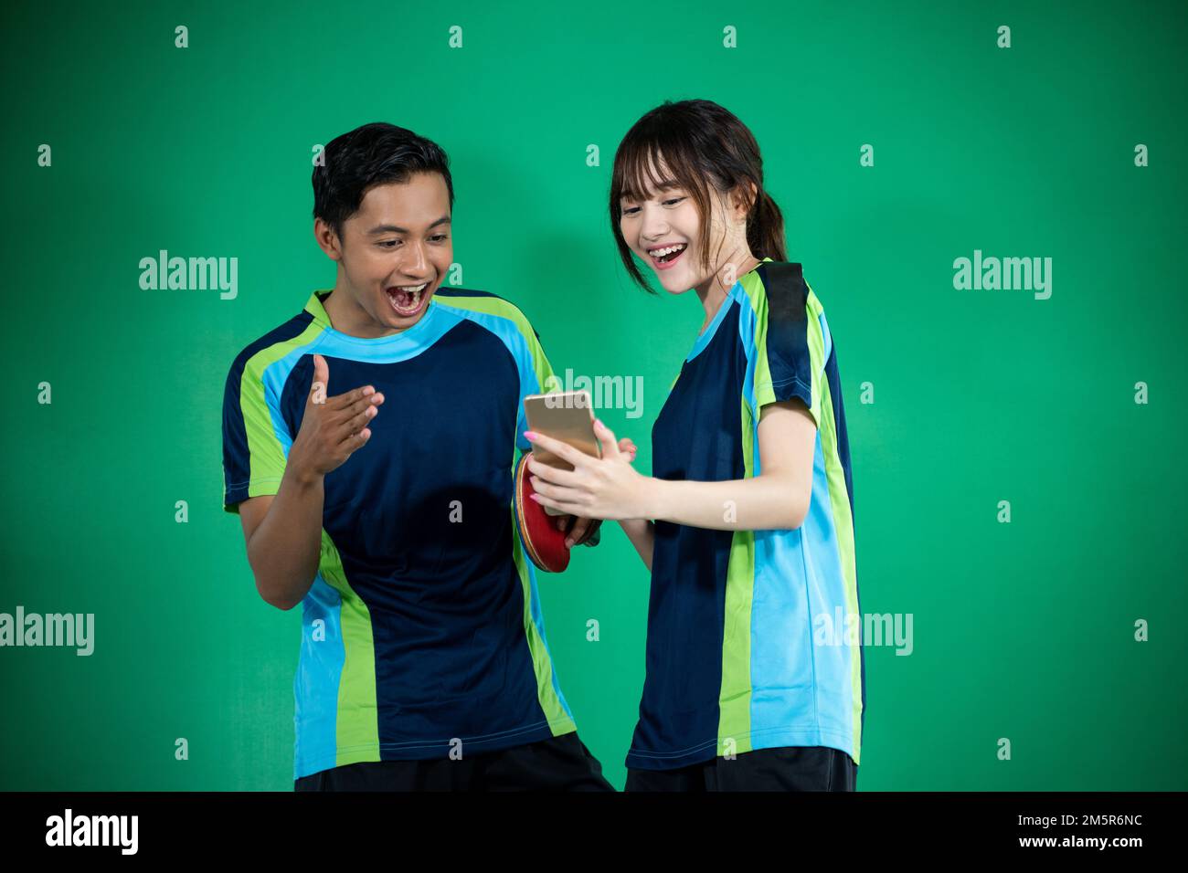 female and male athletes are very excited to see smartphone Stock Photo