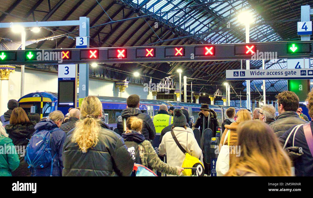 Glasgow, Scotland, UK 30th December, 2022. UK Weather: Rain affects trains and large crowds of passengers watch boards anxiously in queen street station . Credit Gerard Ferry/Alamy Live News Stock Photo