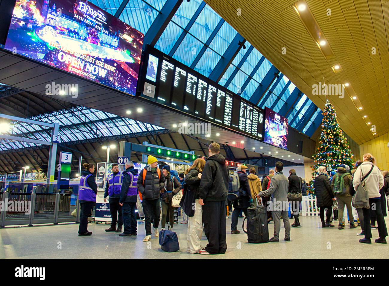Glasgow, Scotland, UK 30th December, 2022. UK Weather: Rain affects trains and large crowds of passengers watch boards anxiously in queen street station . Credit Gerard Ferry/Alamy Live News Stock Photo