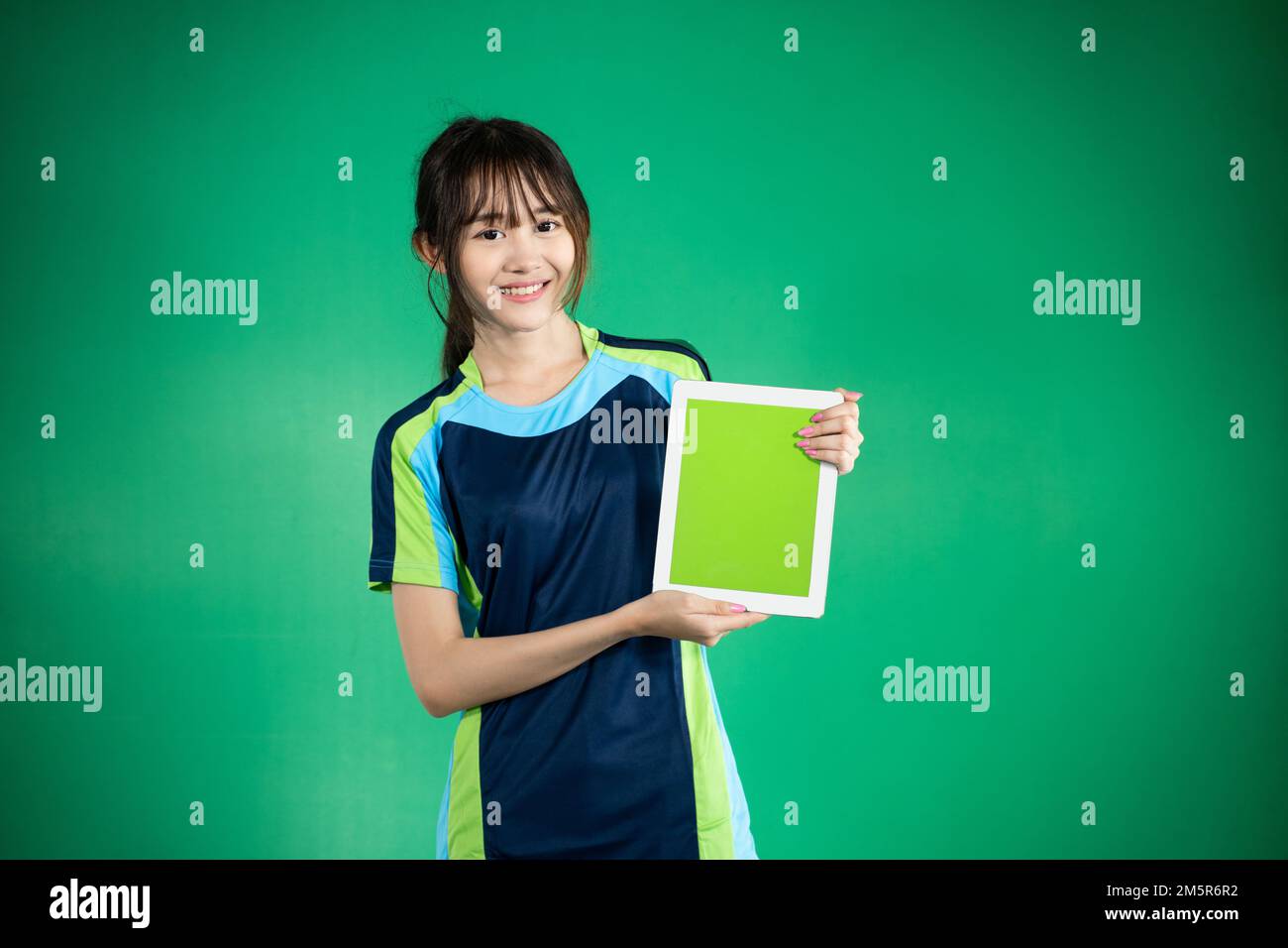 Smiling female table tennis athlete showing blank tablet screen stock