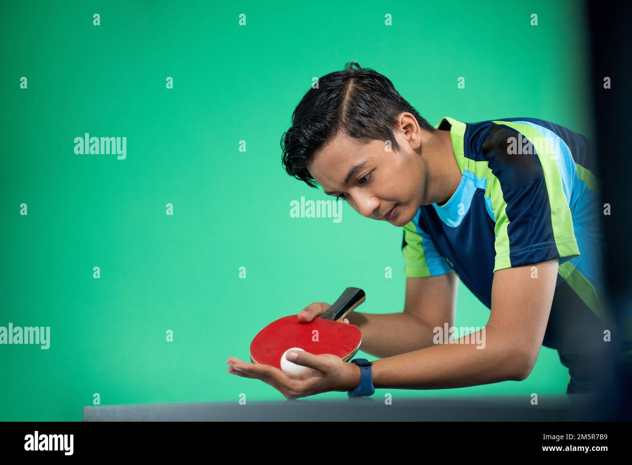Asian athlete ready to serve during a ping pong match Stock Photo