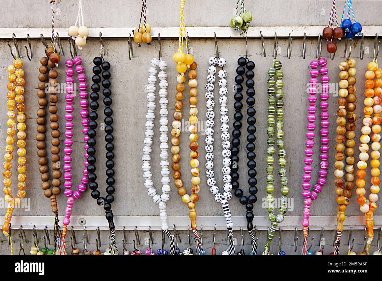 Many rosaries in various colors and materials are exposed at the shop Stock Photo
