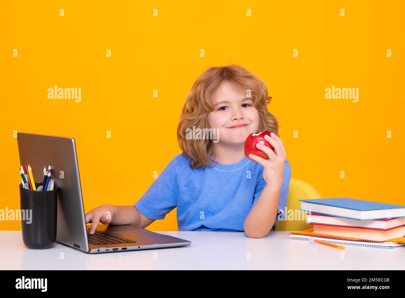 Kid boy from elementary school with book. Little student, smart nerd pupil ready to study. Concept of education and learning. Stock Photo