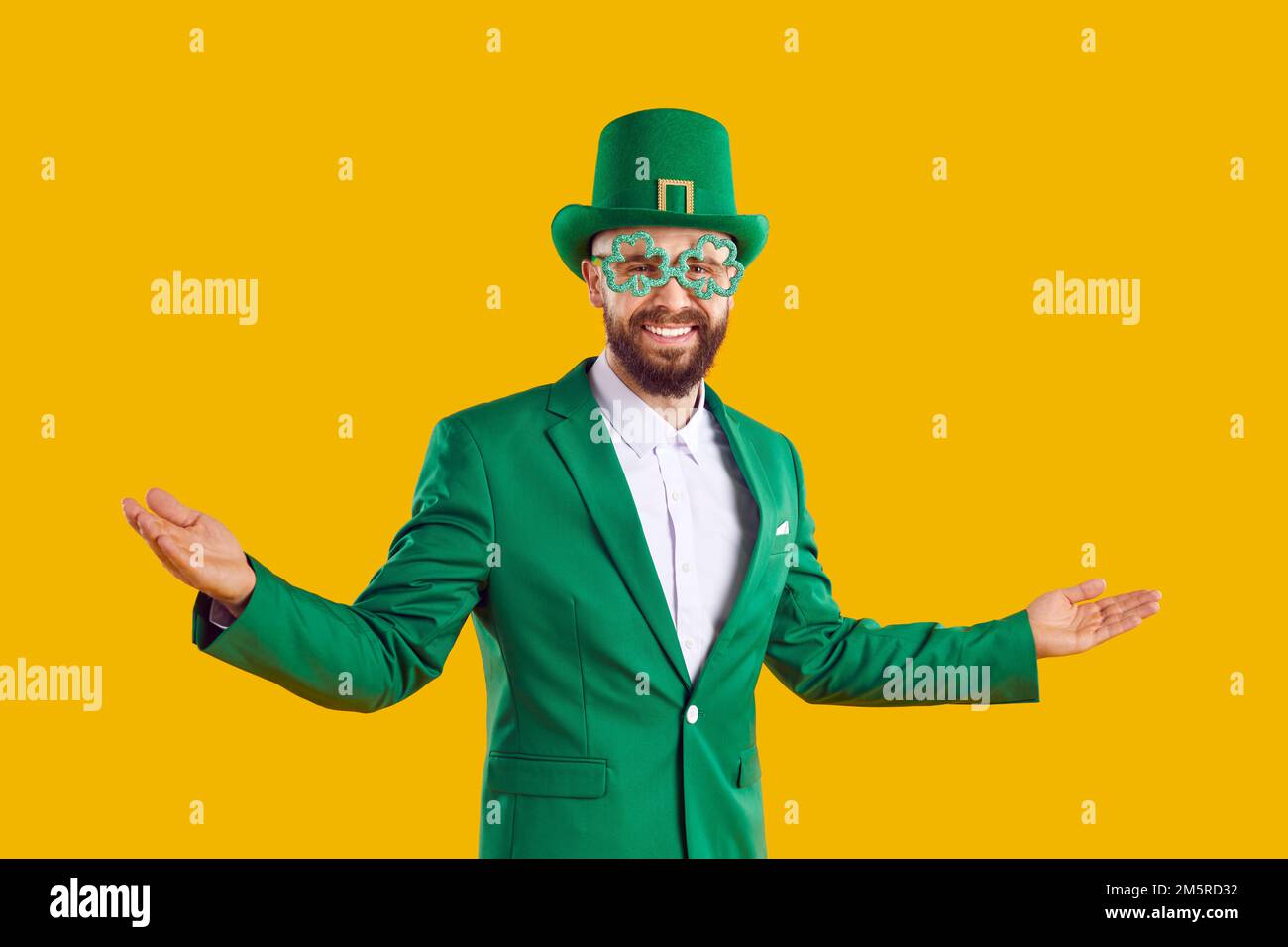Happy man in green suit, hat and funny glasses welcomes you to St Patrick's Day Party Stock Photo