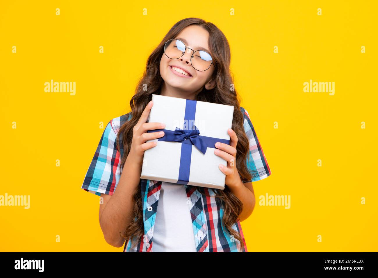 Portrait of a teenager child girl holding present box isolated over ...