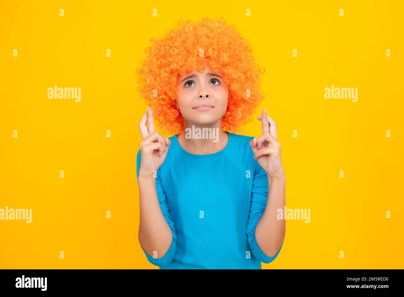 Girl with yellow wig. Funny child wearing orange curly wig hair, summer