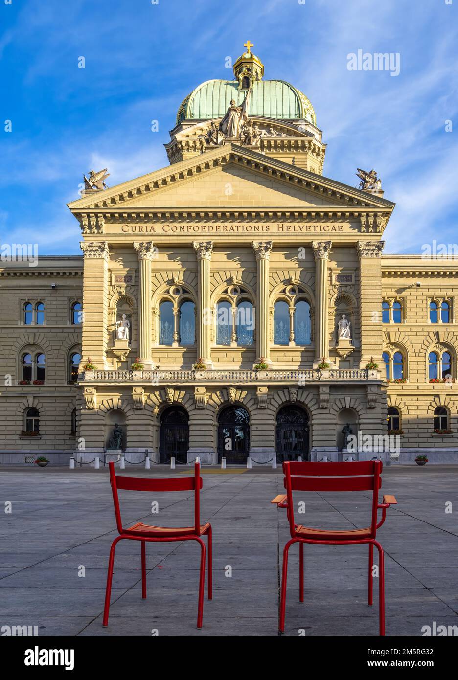 Bern, Switzerland - July 12, 2022: Two red chairs in front of the Federal parliament building in Bern, Switzerland Stock Photo