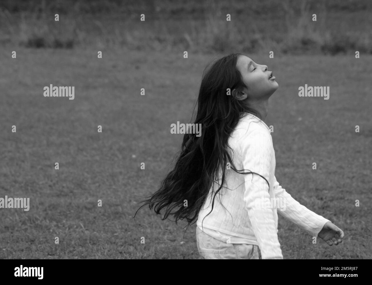 Side view of young girl standing on field Stock Photo - Alamy