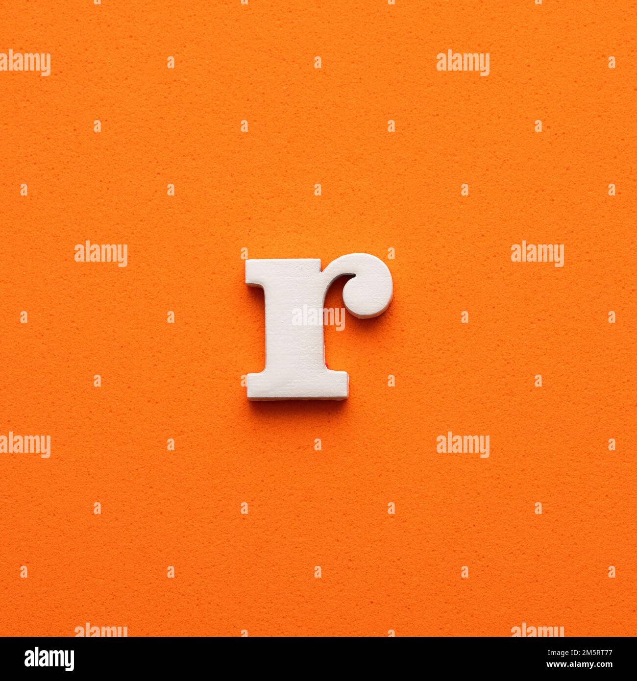 White lowercase letter r on orange foamy background Stock Photo