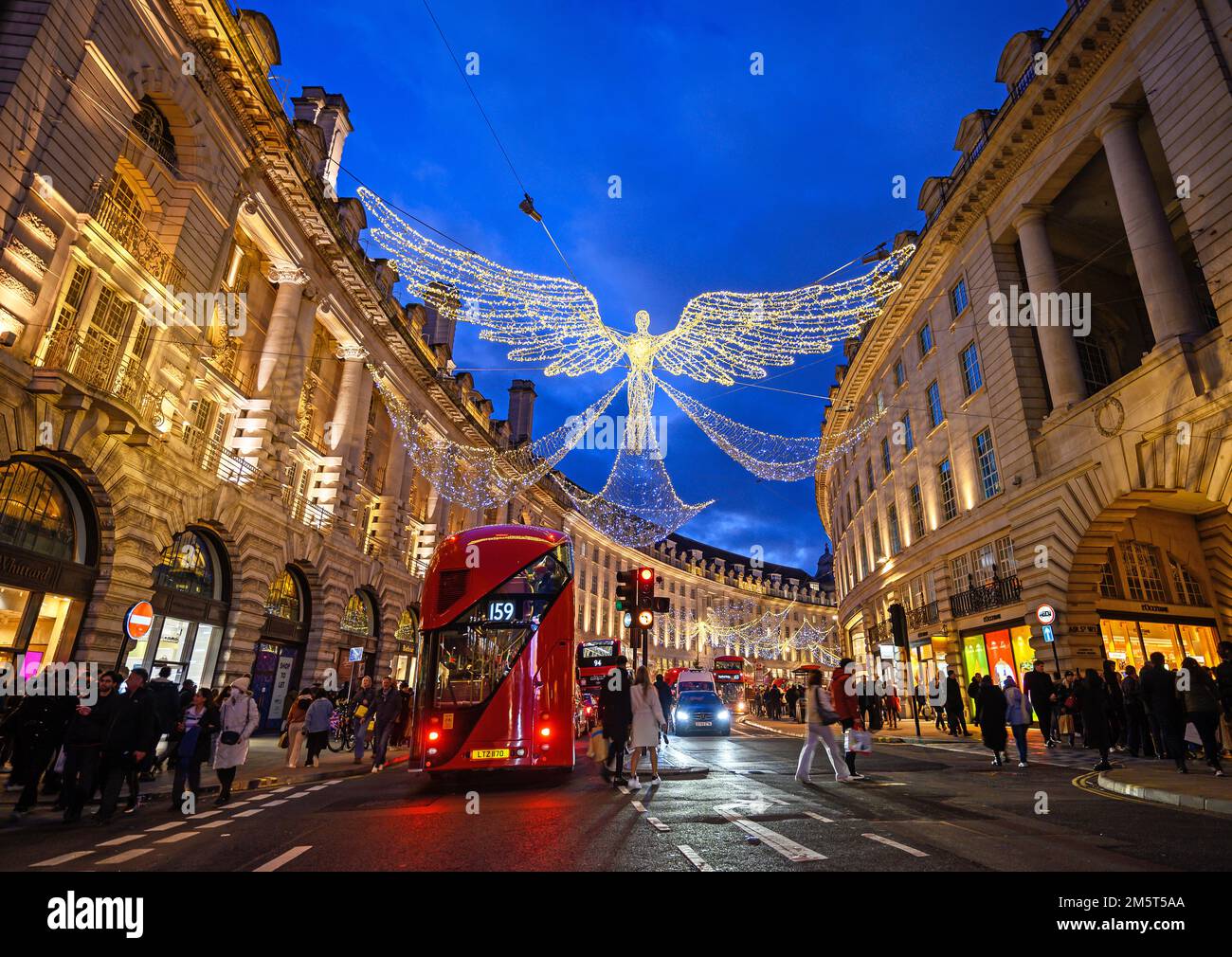 People and traffic along Regent Street in London, UK. Evening view of Regent Street with Christmas lights above the road Stock Photo