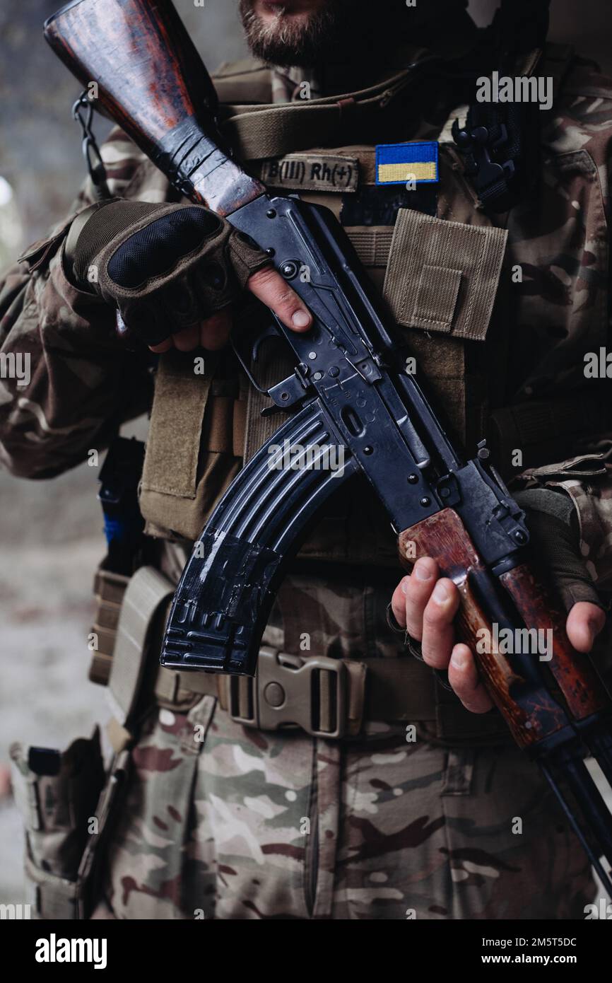 A soldier is holding an assault rifle, close-up Stock Photo - Alamy