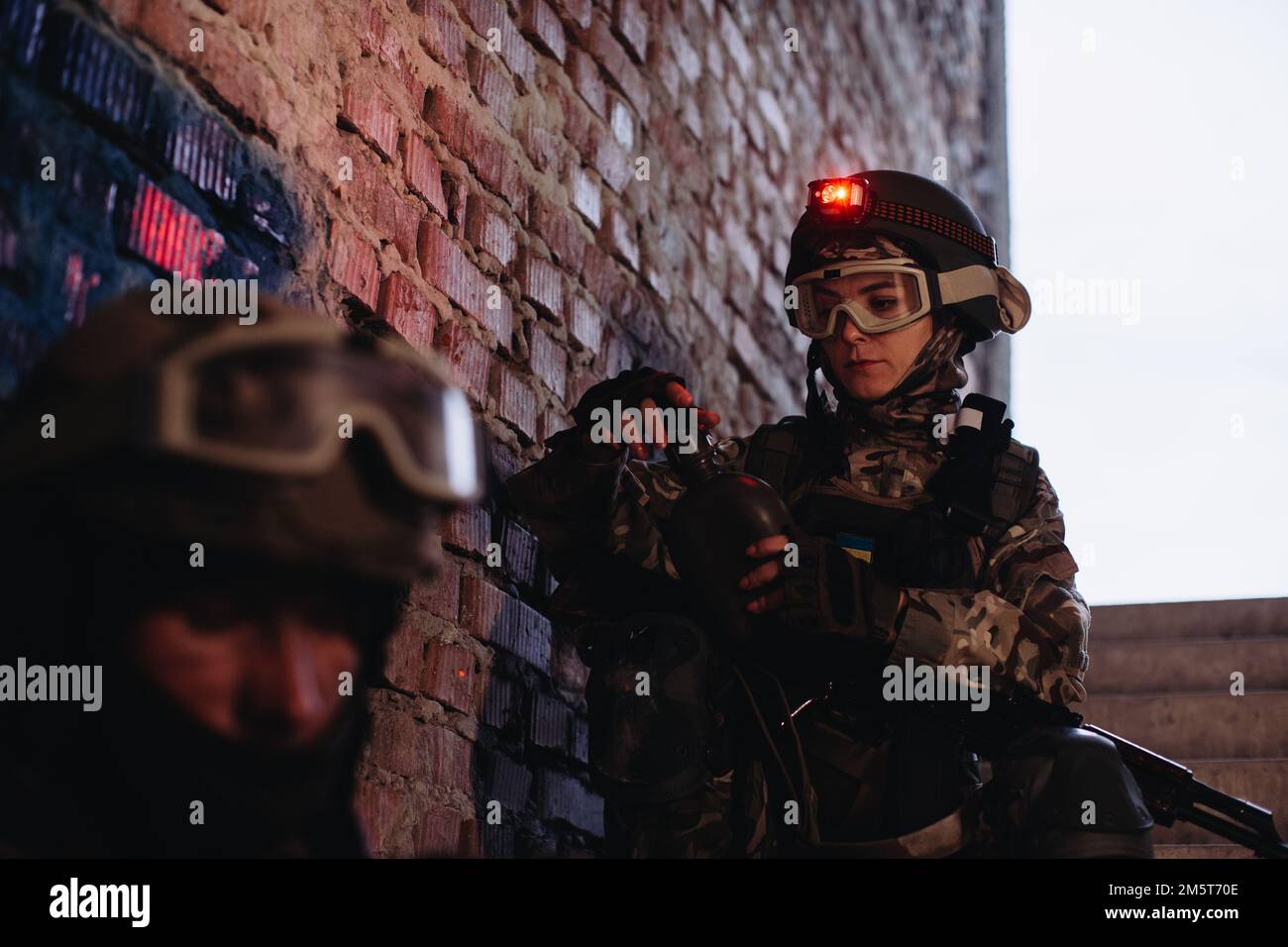A female soldier drinks water while resting. Ukrainian Military in the ...