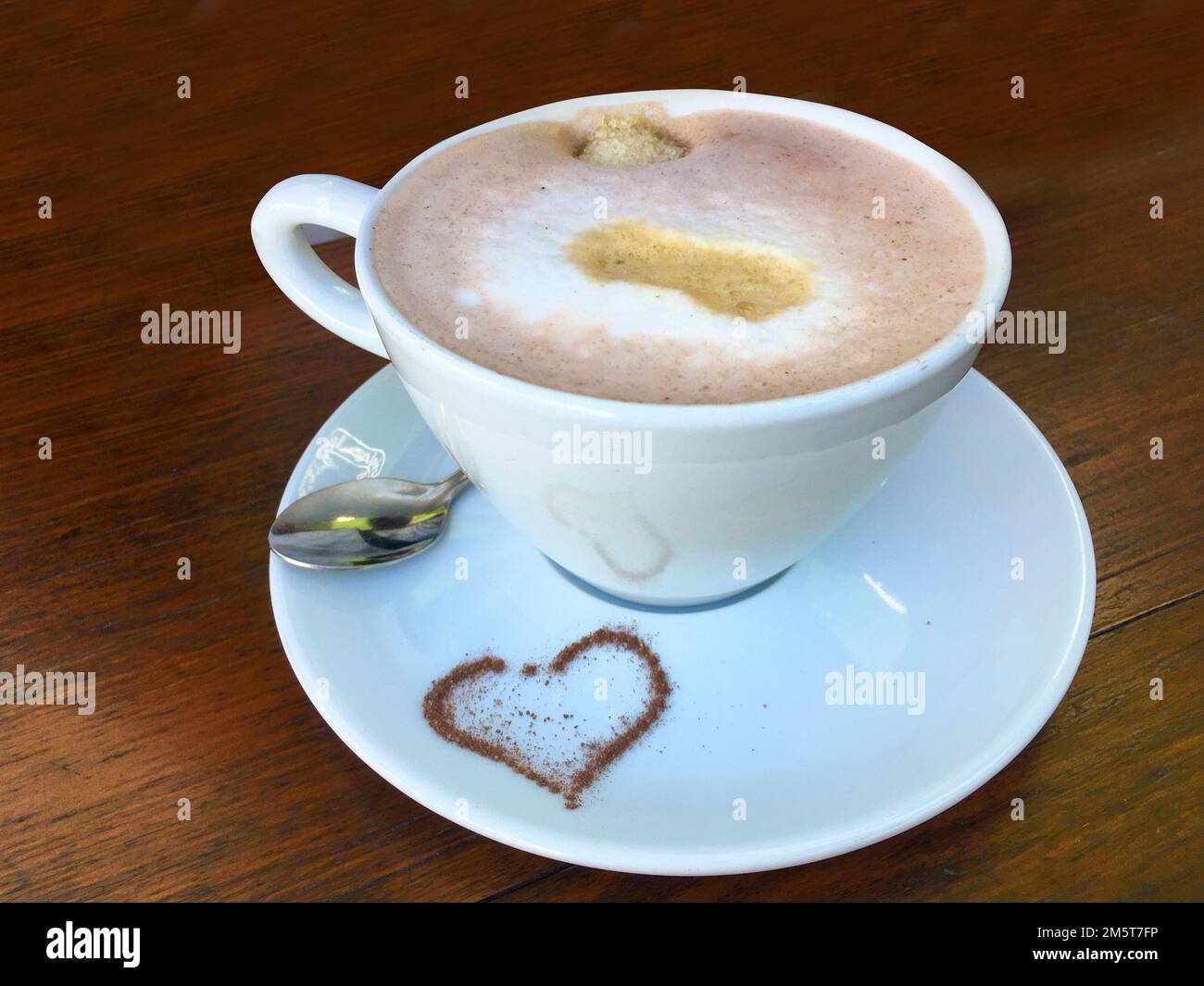 Tasse Cappuccino mit einem Herz aus Kakao und verziertem Milchschaum ...