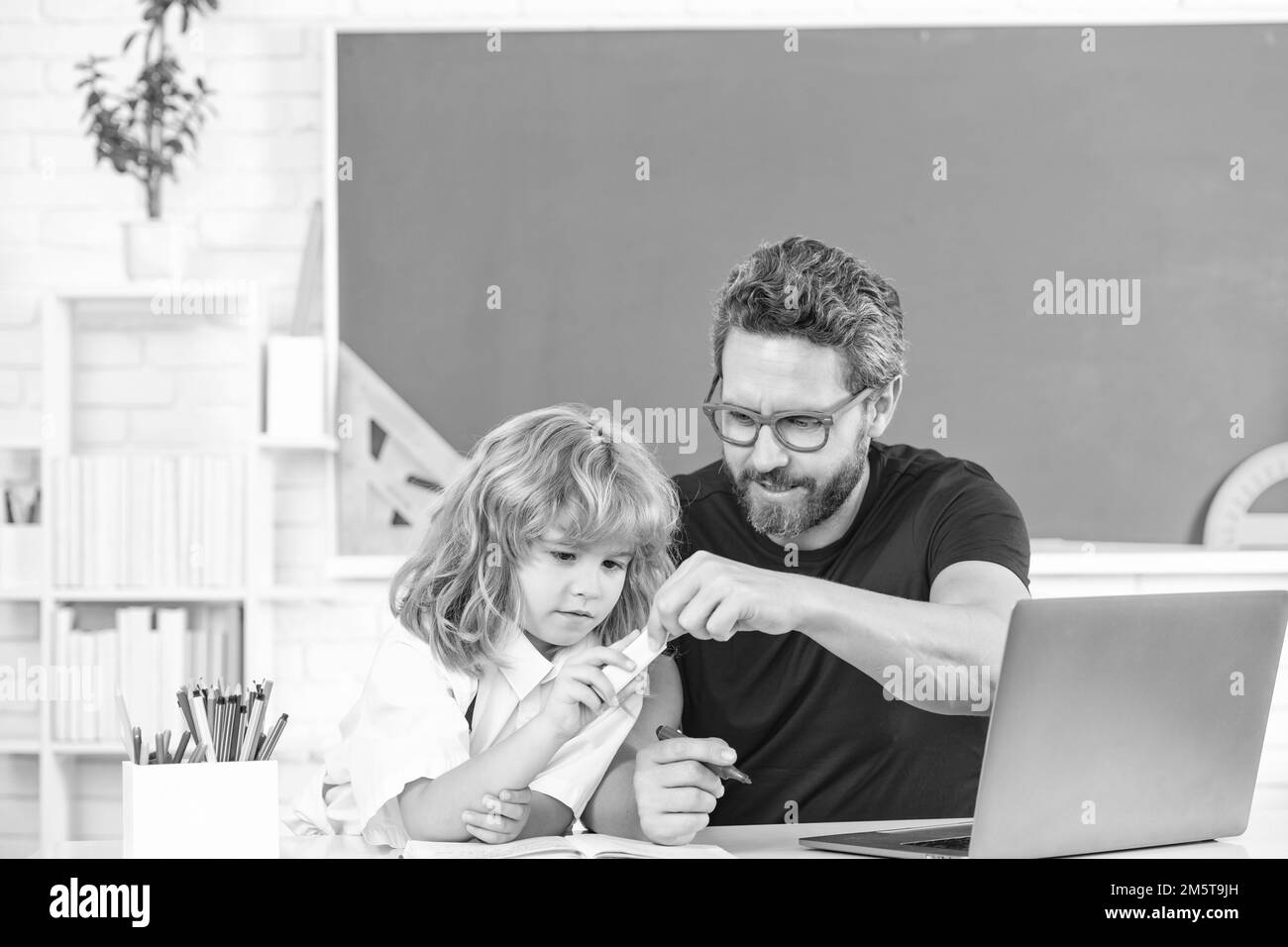 father and child study in classroom with laptop, knowledge Stock Photo