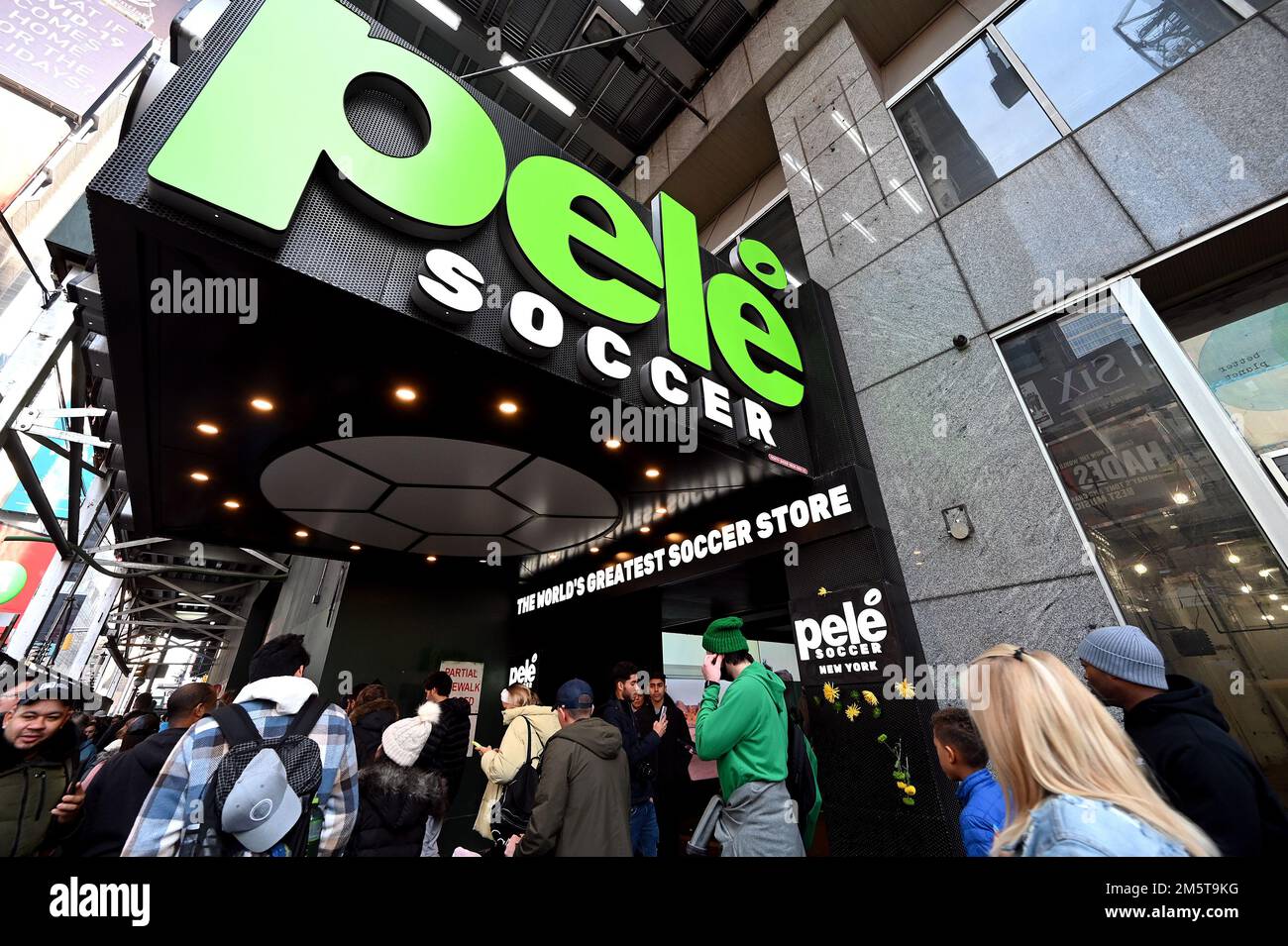 New York, USA. 30th Dec, 2022. A woman walks past flowers placed on the front of the Pele Soccer