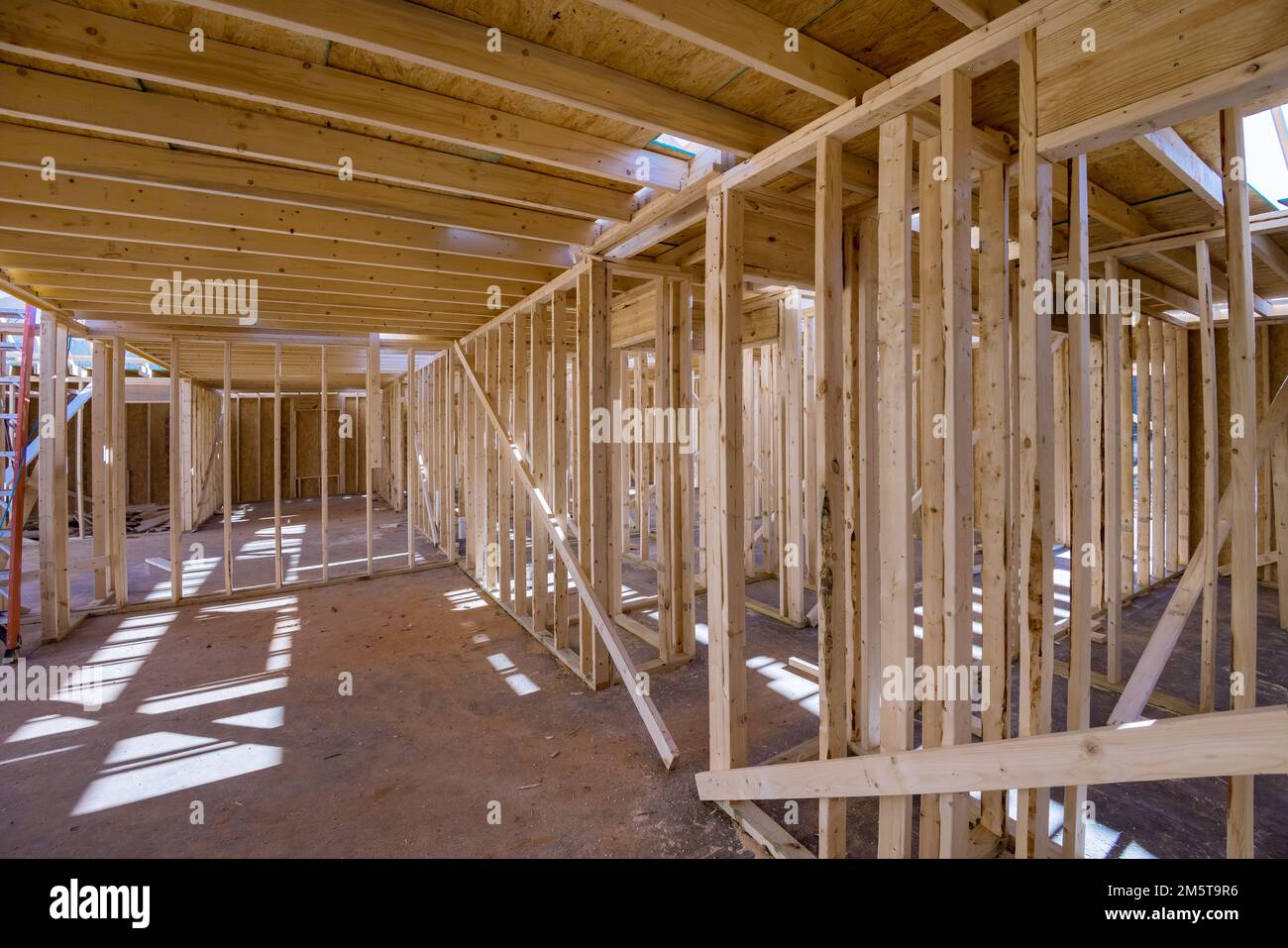 An interior new house under construction with wood framing beams stick ...