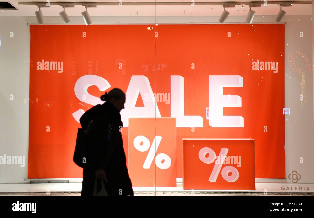 Berlin, Germany. 30th Dec, 2022. A woman walks past a store window with